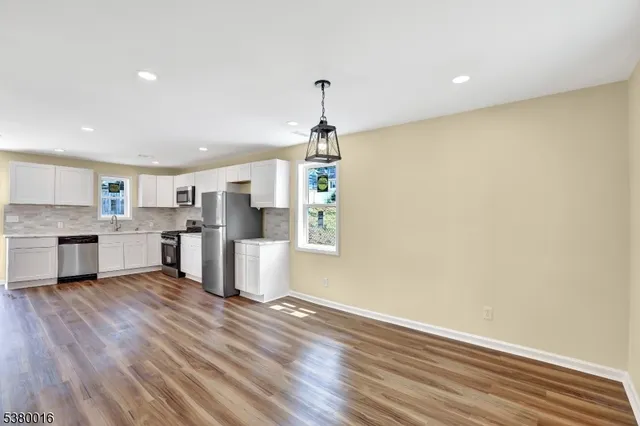 a view of a kitchen with furniture and wooden floor