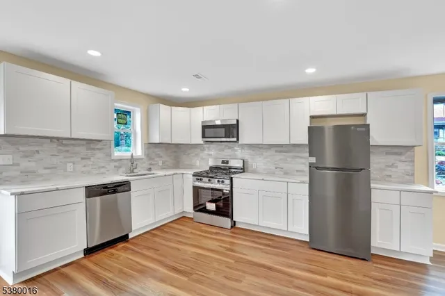a kitchen with a refrigerator stove top oven and sink