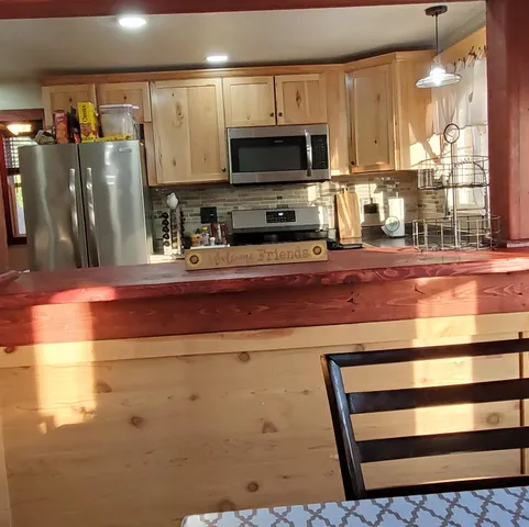 a kitchen with stainless steel appliances a refrigerator and a stove top oven