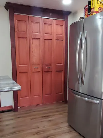 an empty room with wooden floor cabinet and staircase