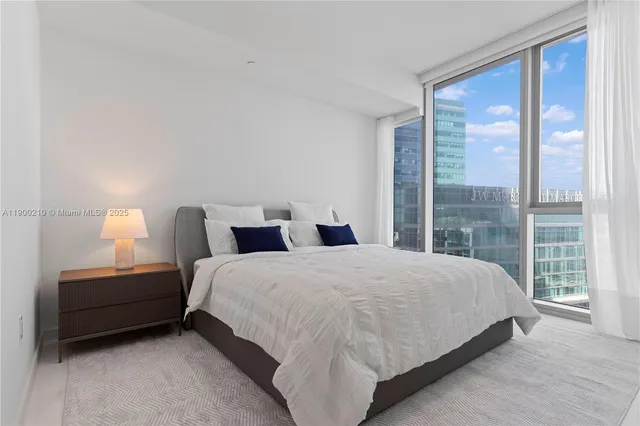 a large bed sitting in a bedroom next to a window