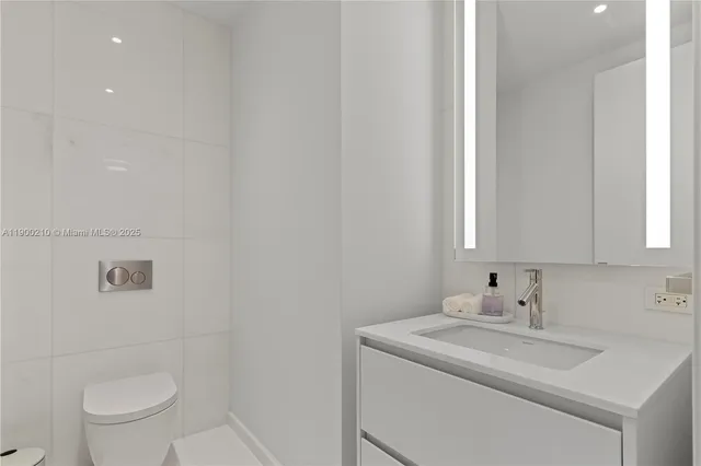 a bathroom with a sink toilet and a mirror