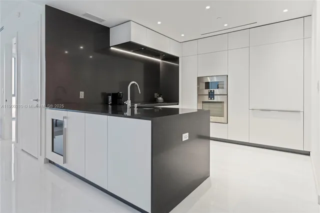 a kitchen with kitchen island a refrigerator and a sink