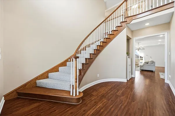 a view of a hallway with wooden floor and staircase