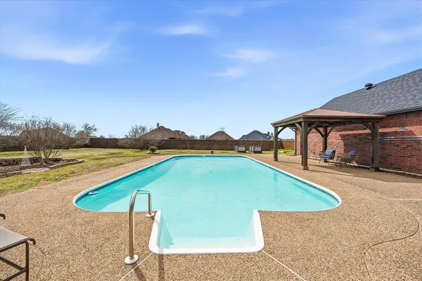 a view of a house with a swimming pool and a yard