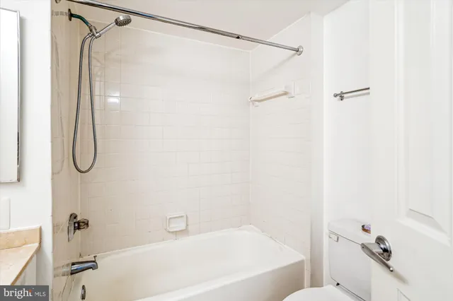 a bathroom with a granite countertop toilet sink and mirror