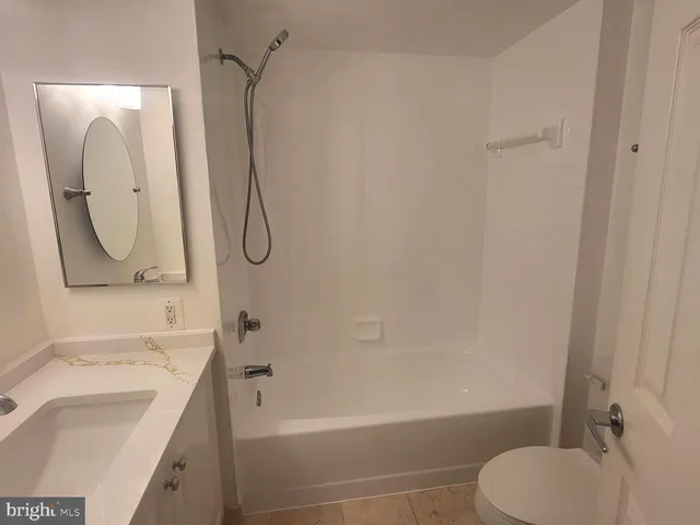 a bathroom with a granite countertop toilet sink and mirror