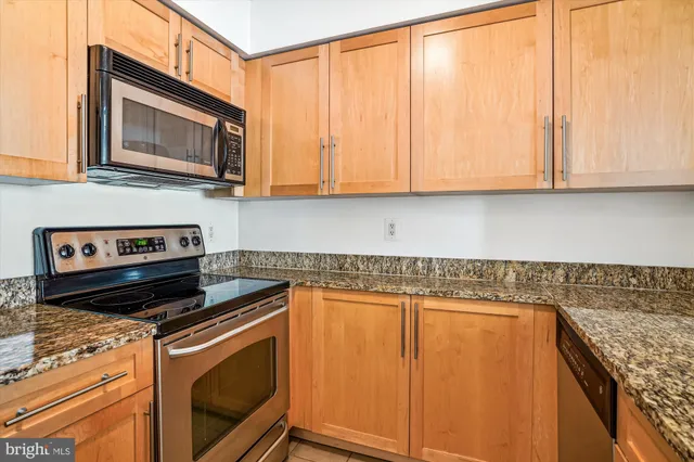 a kitchen with granite countertop cabinets stainless steel appliances and a sink