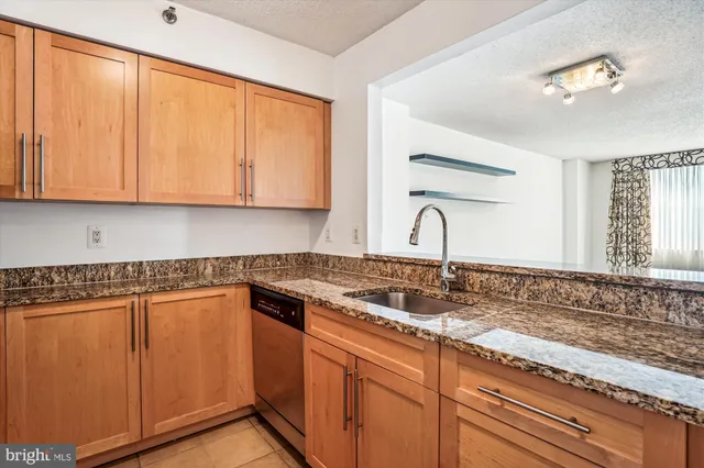 a kitchen with granite countertop white cabinets and sink
