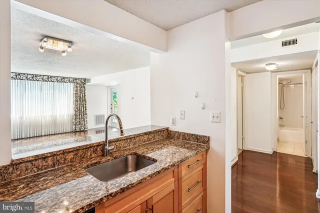a kitchen with a granite countertop sink and cabinets