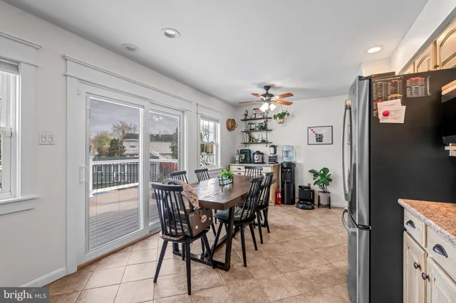 a kitchen with stainless steel appliances granite countertop a refrigerator and a dining table