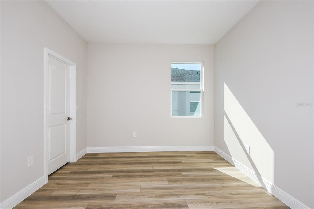 6152 Southwest 97th Street Ocala, FL 34476 - Photo 17 of 31 a view of an empty room with wooden floor and a window