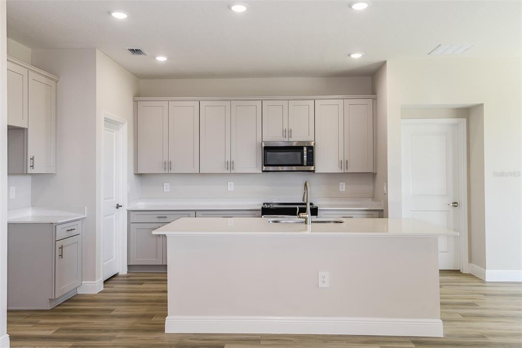 6152 Southwest 97th Street Ocala, FL 34476 - Photo 3 of 31 a room with stainless steel appliances white cabinets and wooden floor