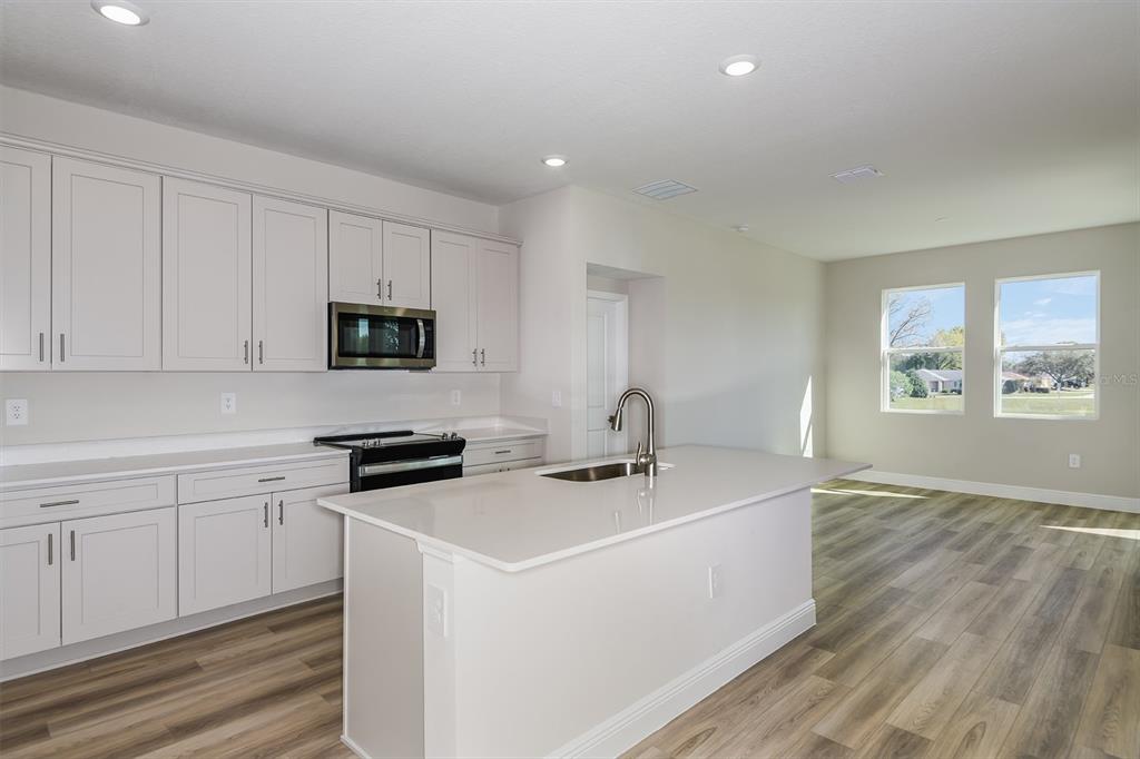 6152 Southwest 97th Street Ocala, FL 34476 - Photo 9 of 31 a kitchen with stainless steel appliances granite countertop a sink a stove a microwave a counter space and cabinets