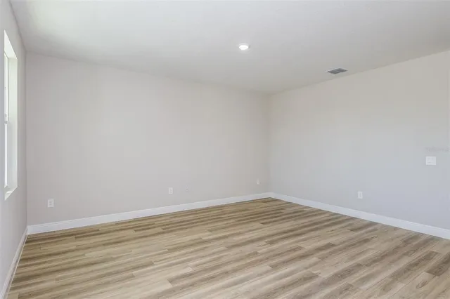 a view of an empty room with wooden floor
