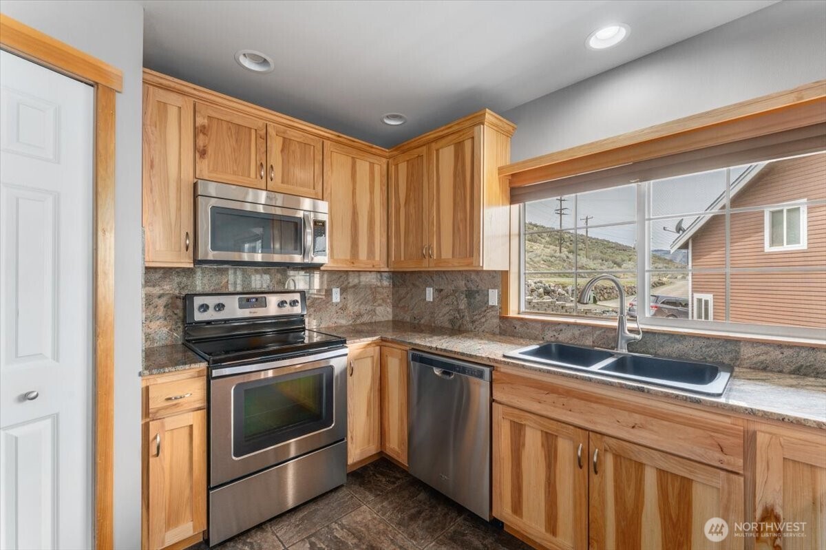 585 Entiat Place Orondo, WA 98843 - Photo 8 of 40 a kitchen with granite countertop a sink stainless steel appliances and cabinets