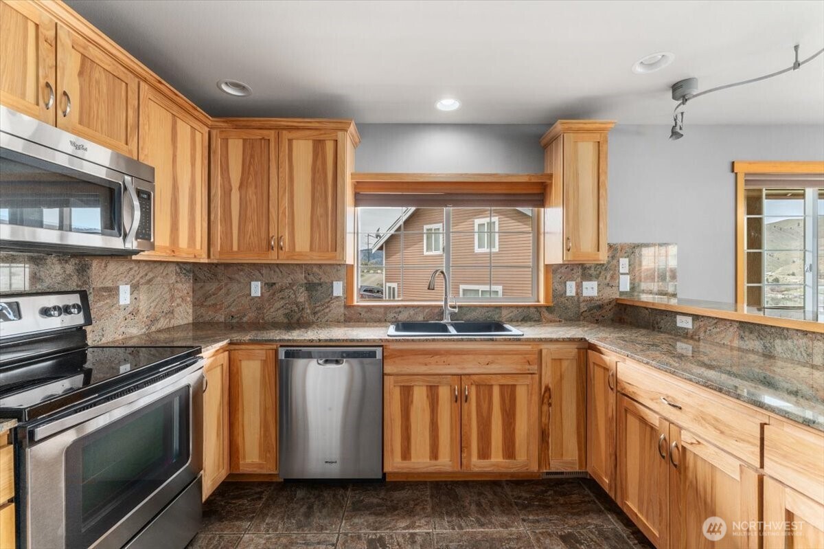 585 Entiat Place Orondo, WA 98843 - Photo 9 of 40 a kitchen with stainless steel appliances granite countertop a stove a sink and a microwave
