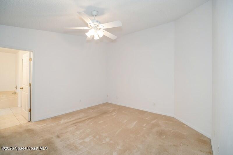 570 Benton Drive Melbourne, FL 32901 - Photo 11 of 26 an empty room with a chandelier fan