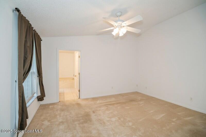 570 Benton Drive Melbourne, FL 32901 - Photo 12 of 26 an empty room with a chandelier fan and windows