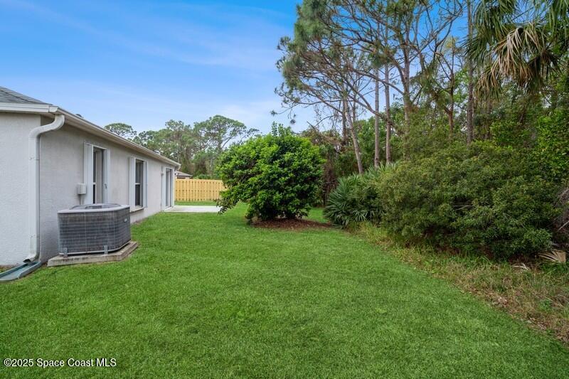570 Benton Drive Melbourne, FL 32901 - Photo 22 of 26 a view of a backyard with plants and a large tree