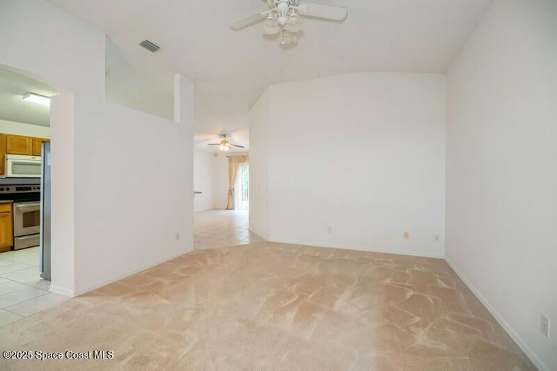 570 Benton Drive Melbourne, FL 32901 - Photo 3 of 26 an empty room with a chandelier fan and windows
