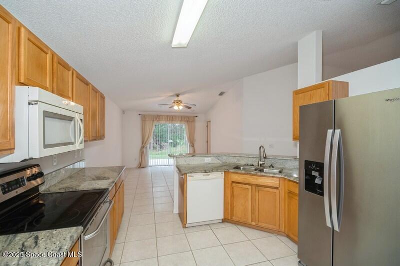 570 Benton Drive Melbourne, FL 32901 - Photo 7 of 26 a kitchen with a stove a refrigerator and a sink