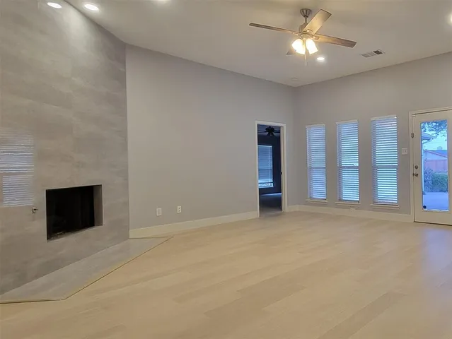 an empty room with fan and windows