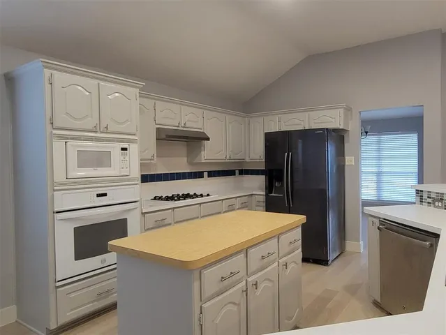 a kitchen with a refrigerator stove and sink