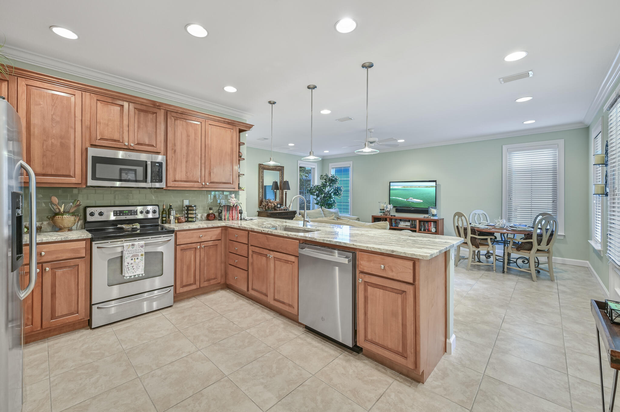 100 South Zander Way Santa Rosa Beach, FL 32459 - Photo 4 of 40 a kitchen with stainless steel appliances granite countertop a stove top oven a sink dishwasher a dining table and chairs with wooden floors