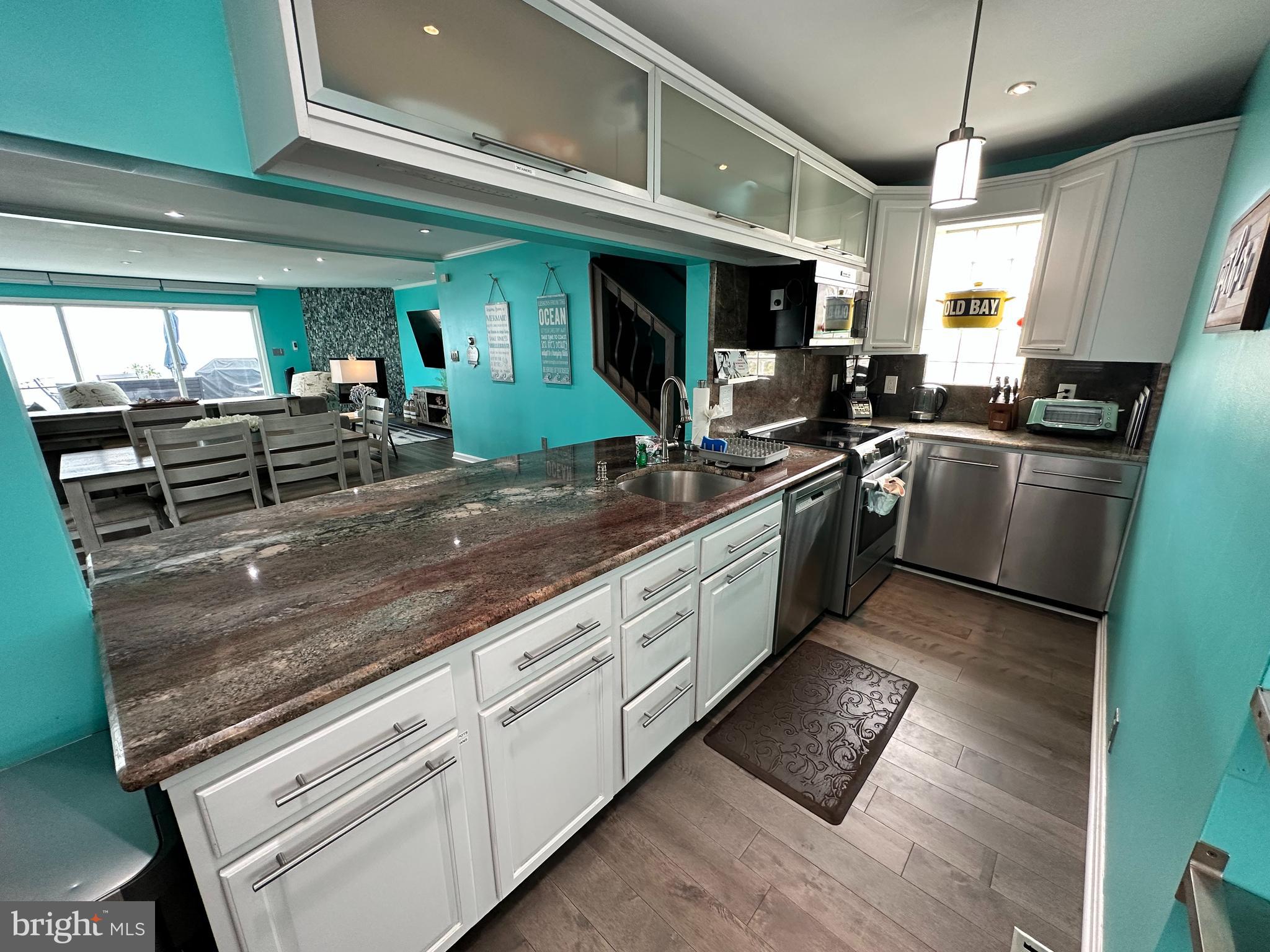 7517 B Street Chesapeake Beach, MD 20732 - Photo 45 of 78 a kitchen with stainless steel appliances granite countertop a sink counter space cabinets and a window