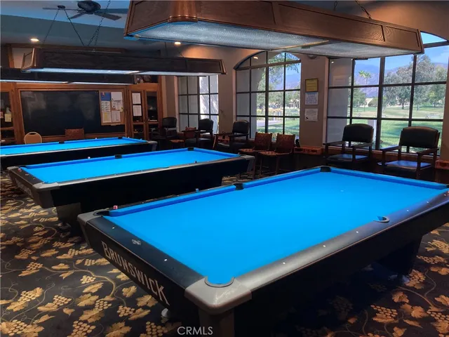 a room with pool table and windows