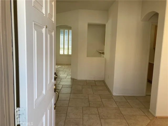 a view of a hallway with wooden cabinets and a glass door