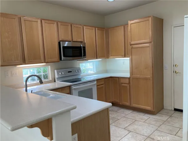 a kitchen with kitchen island granite countertop stainless steel appliances and cabinets