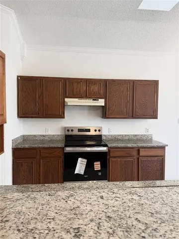 a kitchen with stainless steel appliances granite countertop a stove a sink and a microwave