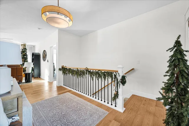 a view of a room with wooden floor and pendant lights
