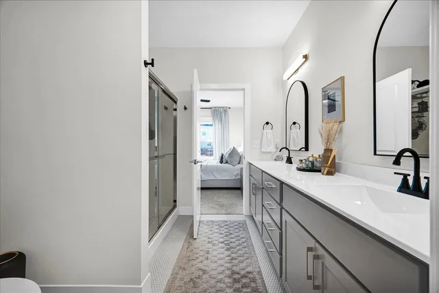 a en suite bathroom with a double vanity sink and a mirror