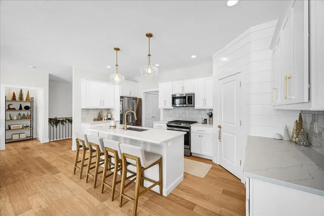 a kitchen with stainless steel appliances kitchen island granite countertop a table chairs and a refrigerator