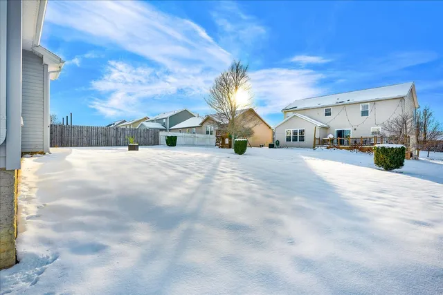 a view of a house with backyard and a tree