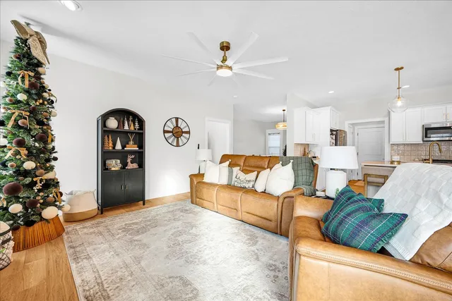 a living room with furniture cabinets and a chandelier