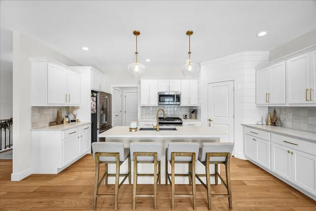 a kitchen with stainless steel appliances kitchen island granite countertop a kitchen island hardwood floor and stove