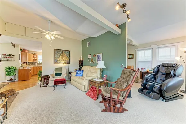 a living room with furniture a fireplace and large windows