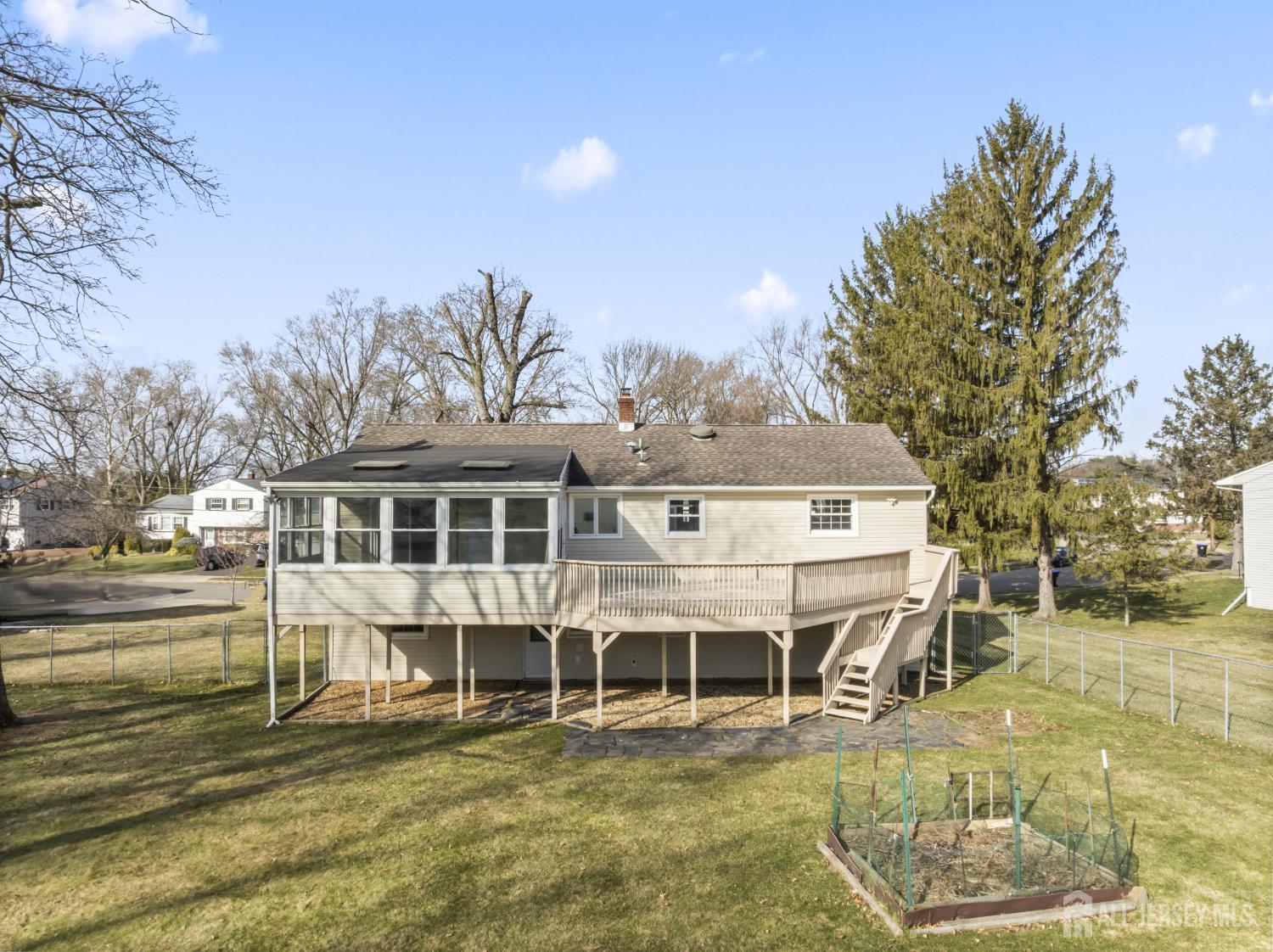 8 Tompkins Road East Brunswick, NJ 08816 - Photo 15 of 22 a big white house with a large pool and lawn chairs under an umbrella