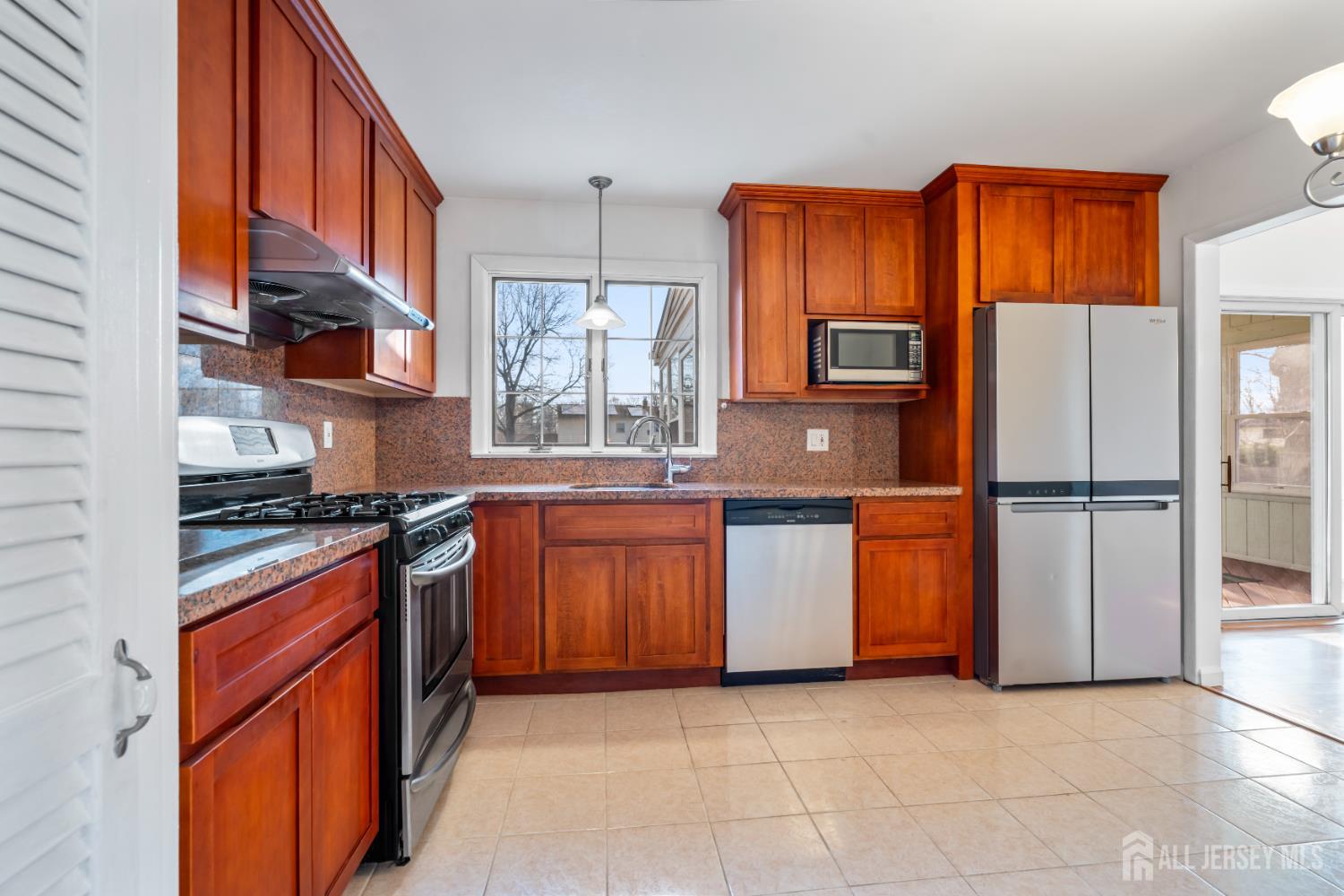 8 Tompkins Road East Brunswick, NJ 08816 - Photo 4 of 22 a kitchen with stainless steel appliances granite countertop a stove a sink and a refrigerator