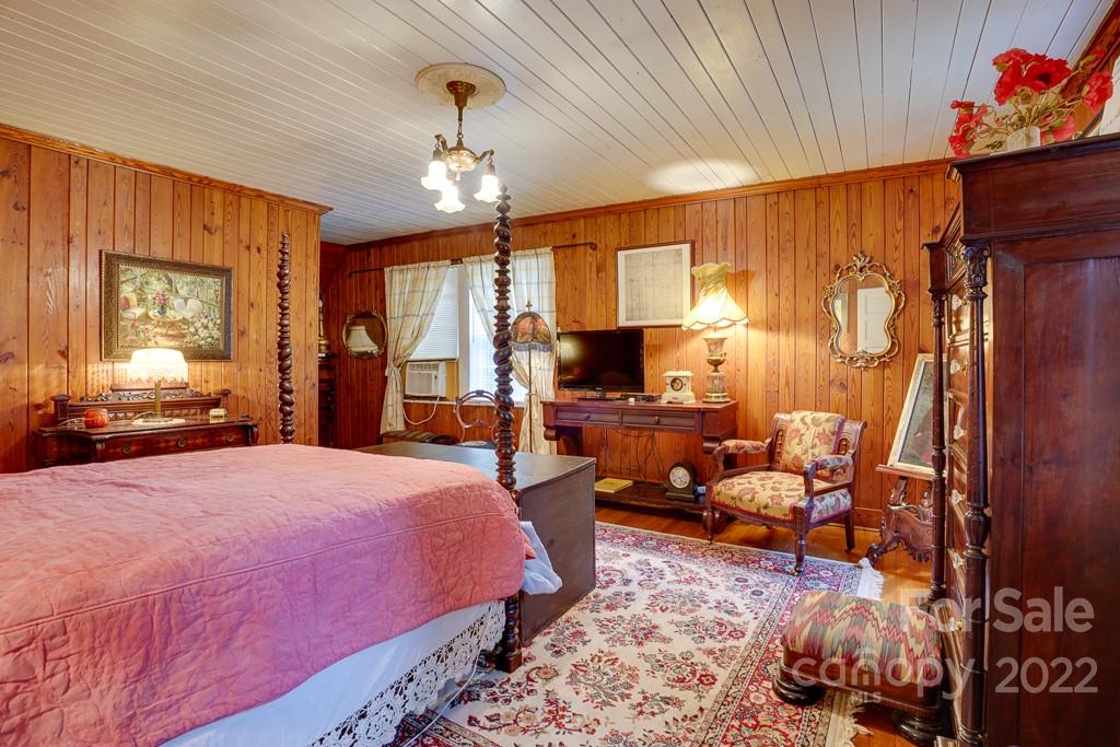 60 Mimosa Inn Drive Tryon, NC 28782 - Photo 19 of 26 a spacious bedroom with a bed and a chandelier