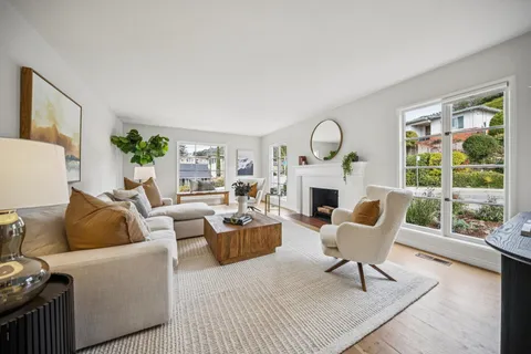 a living room with furniture a large window and a fireplace
