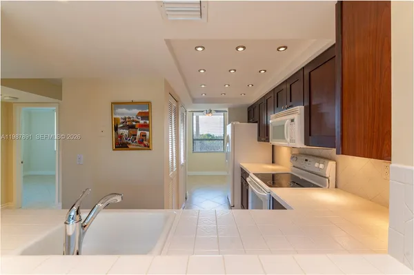 a large kitchen with stainless steel appliances a large counter top a stove and a refrigerator