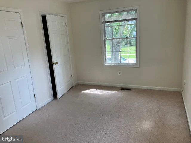 an empty room with windows and closet