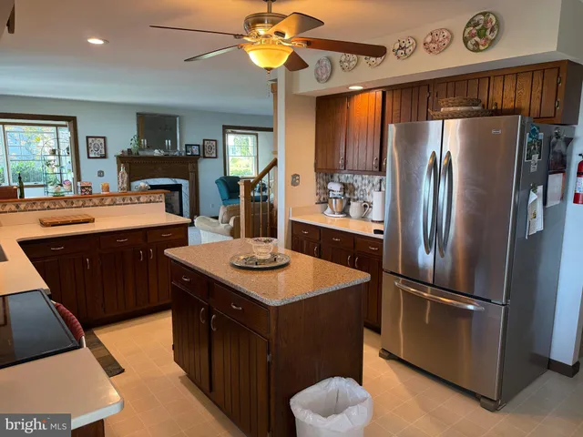 a kitchen with stainless steel appliances a sink a stove a refrigerator cabinets and a dining table