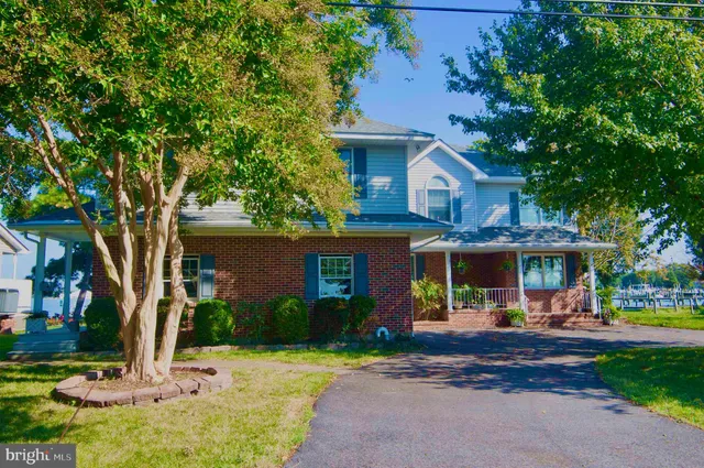a front view of a building with lots of trees and plants