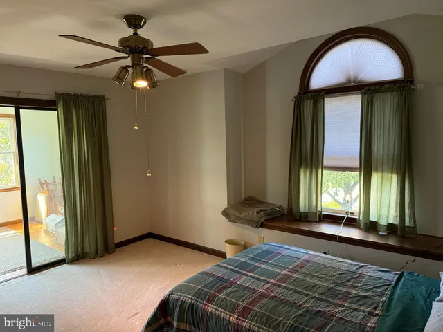 a bedroom with a bed and a large window